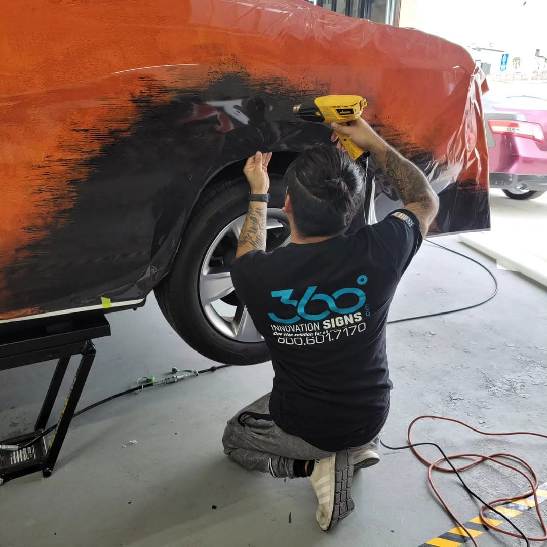 Installer applying vinyl wrap to a vehicle