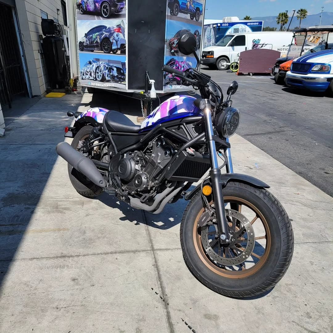 Honda Rebel motorcycle with purple and white custom wrap in the shop